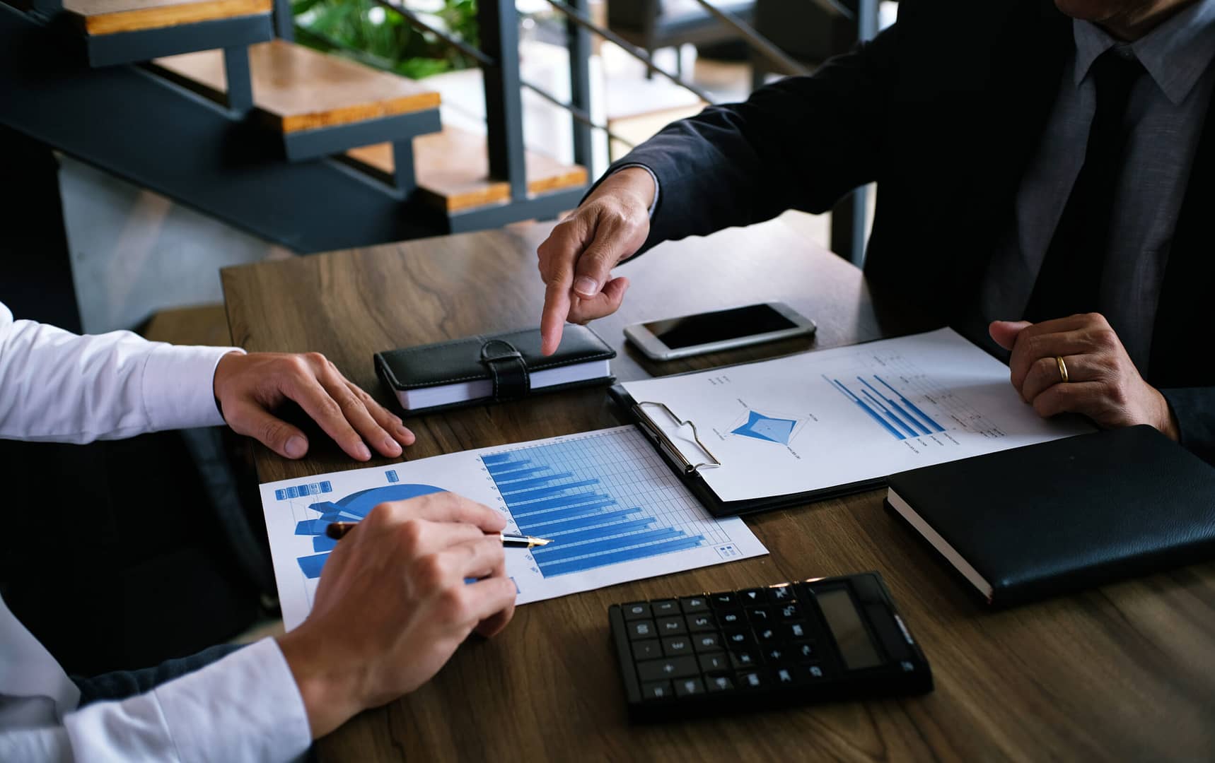 Business meeting analyzing financial charts and graphs on paper