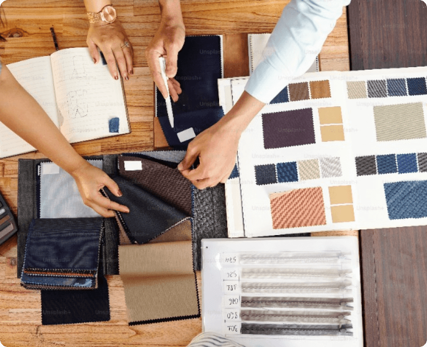 Fabric samples selection process with hands exploring swatches and color palettes on a table